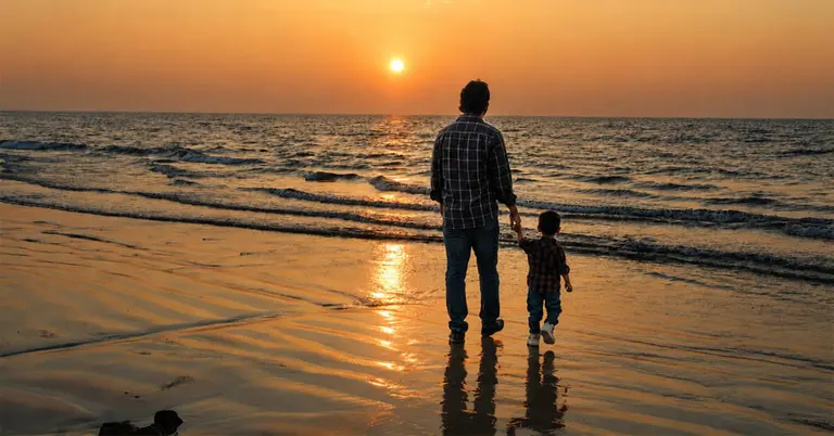 সমুদ্রের পাশে ছোট্ট ছেলেকে নিয়ে সূর্যাস্ত দেখছেন বাবা